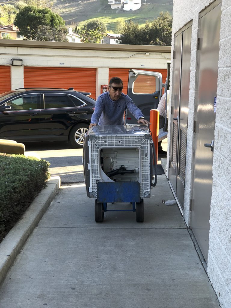 Taskmasters Luis and Liam finally dollying that beast of an appliance into my storage unit.